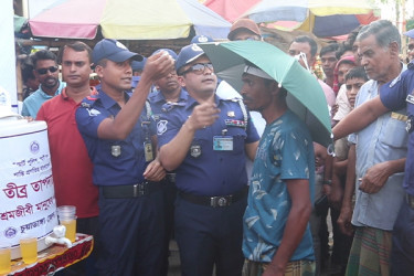 পথচারী ও শ্রমজীবীদের মাঝে ছাতা বিতরণ করলো পুলিশ