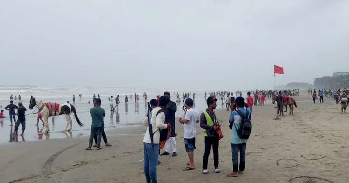 ঝড়ের মধ্যে সৈকতে কী করছেন পর্যটকরা?